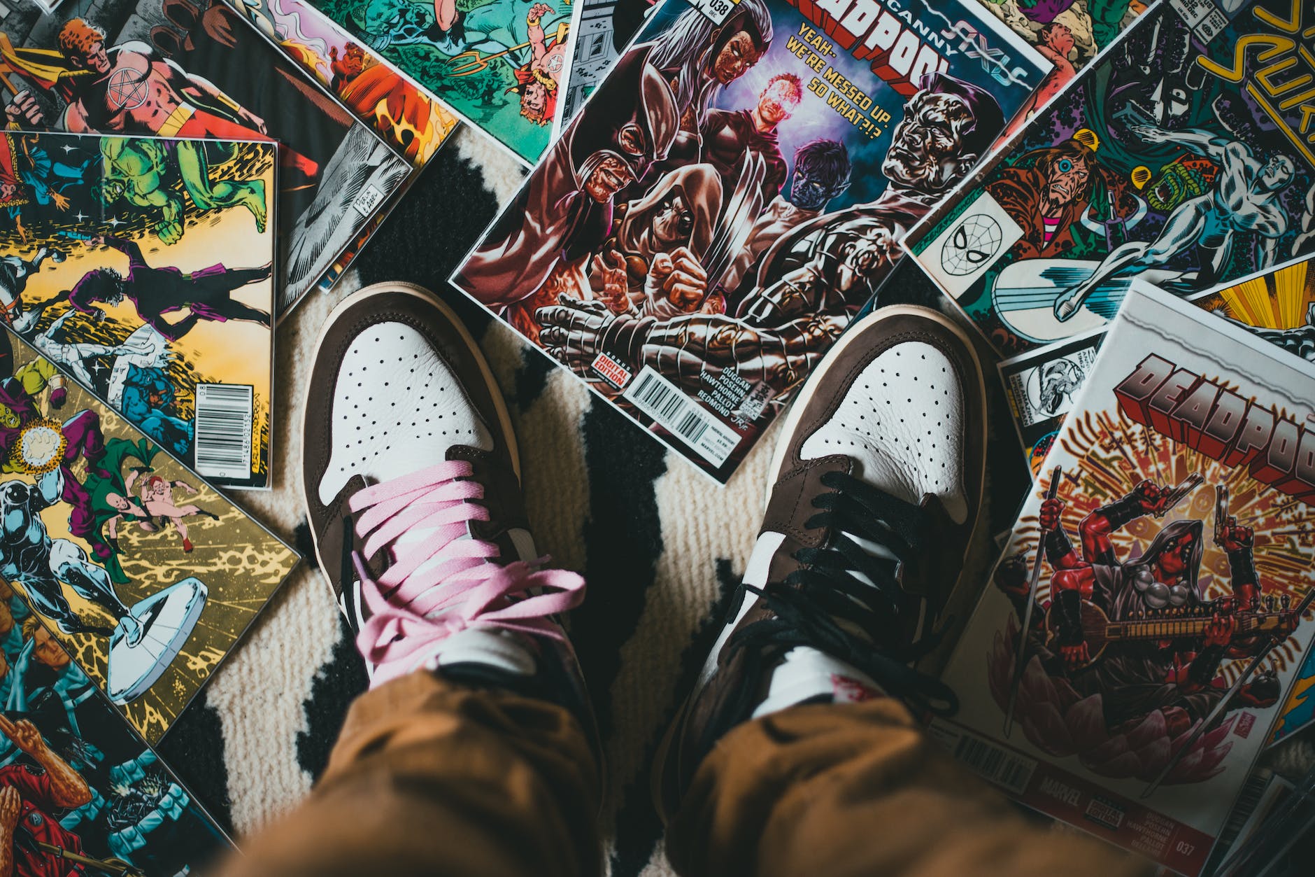 crop person standing on pile of collection of comics books